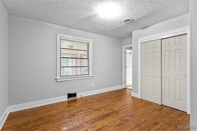 3205 Birchbrook Rd, Henrico, VA 23228 - unfurnished bedroom with a textured ceiling, wood finished floors, and a closet