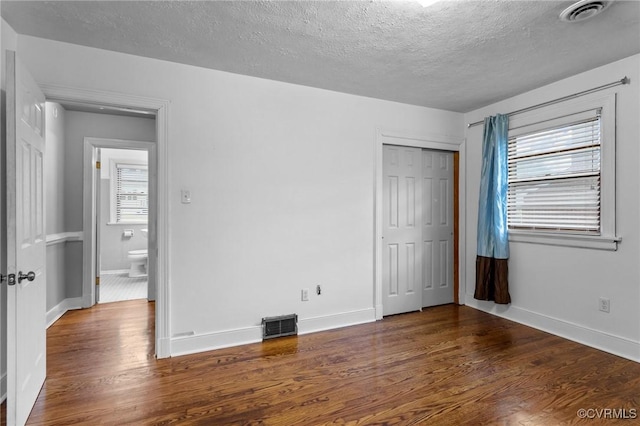 3205 Birchbrook Rd, Henrico, VA 23228 - unfurnished bedroom featuring a textured ceiling, wood finished floors, and a closet