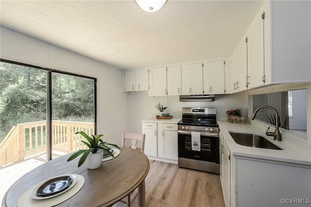 21113 River Rd, Dinwiddie, VA 23885 - kitchen featuring stainless steel range with electric stovetop, light countertops, under cabinet range hood, white cabinets, and light wood-style floors