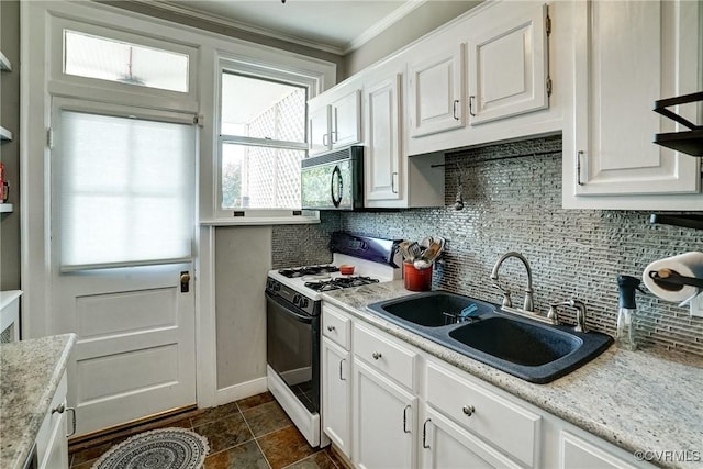 3102 W Grace St, Richmond, VA 23221 - kitchen with gas range, black microwave, tasteful backsplash, white cabinetry, and crown molding