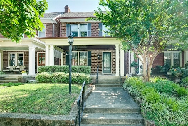 3102 W Grace St, Richmond, VA 23221 - view of front of house featuring brick siding, a chimney, and a front yard