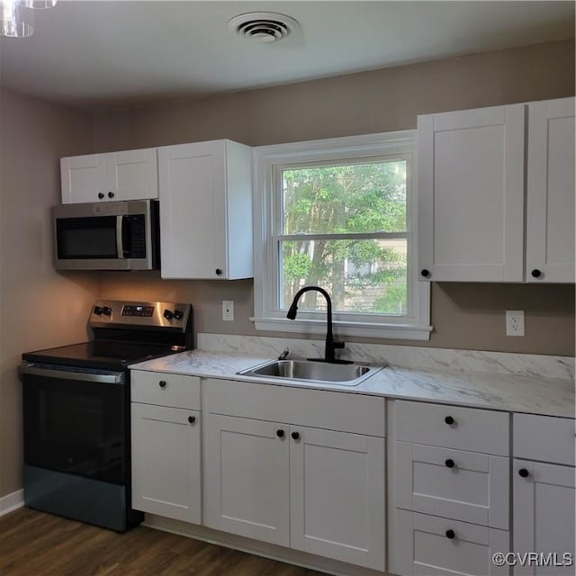 3017 Wright Rd, Petersburg, VA 23805 - kitchen featuring stainless steel microwave, electric range, dark wood finished floors, and white cabinetry