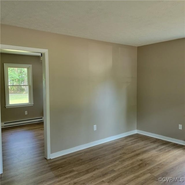3017 Wright Rd, Petersburg, VA 23805 - empty room with a baseboard radiator, dark wood-style floors, and a textured ceiling
