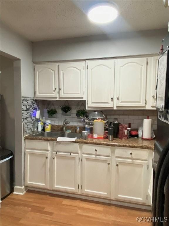 914 Ridgeway Ave, Hampton, VA 23661 - kitchen with white cabinetry, backsplash, light wood finished floors, and a textured ceiling