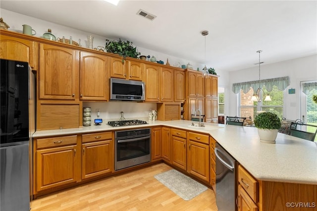9316 Crossover Dr, Mechanicsville, VA 23116 - kitchen with stainless steel appliances, a peninsula, light wood finished floors, light countertops, and brown cabinets