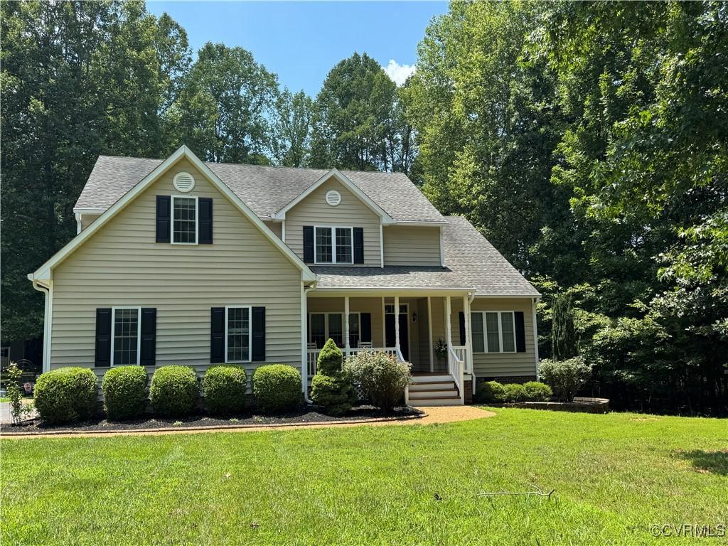 2669 Dorset Meadows Dr, Powhatan, VA 23139 - view of front facade with covered porch, a front yard, and roof with shingles