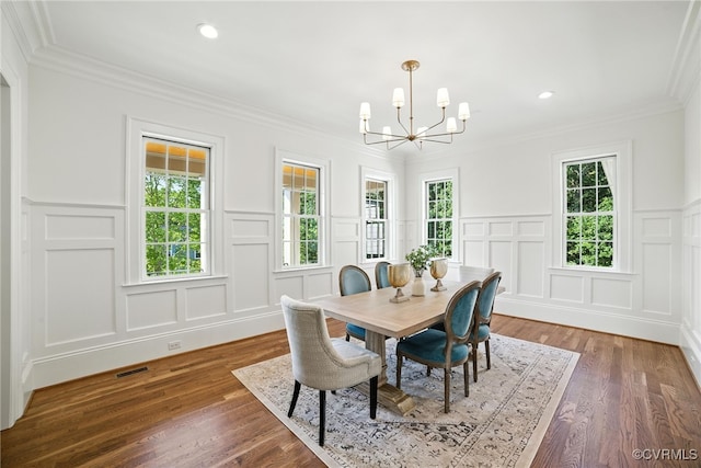 9301 Carriage Stone Ct, Richmond, VA 23235 - dining space featuring a decorative wall, a chandelier, crown molding, wood finished floors, and wainscoting
