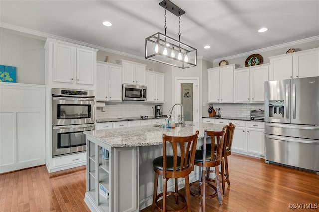 14919 Bayfront Pl, Midlothian, VA 23112 - kitchen with appliances with stainless steel finishes, ornamental molding, a breakfast bar area, backsplash, and a kitchen island with sink