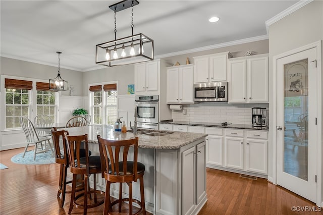 14919 Bayfront Pl, Midlothian, VA 23112 - kitchen featuring stainless steel appliances, an island with sink, tasteful backsplash, a kitchen bar, and dark wood-style flooring