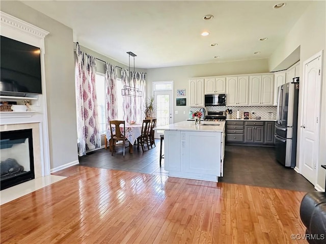43314 Fullerton St, Ashburn, VA 20147 - kitchen with freestanding refrigerator, light countertops, hardwood / wood-style flooring, decorative backsplash, and recessed lighting