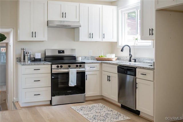 4205 W End Dr, Henrico, VA 23294 - kitchen with appliances with stainless steel finishes, under cabinet range hood, white cabinetry, light stone counters, and light wood-style floors