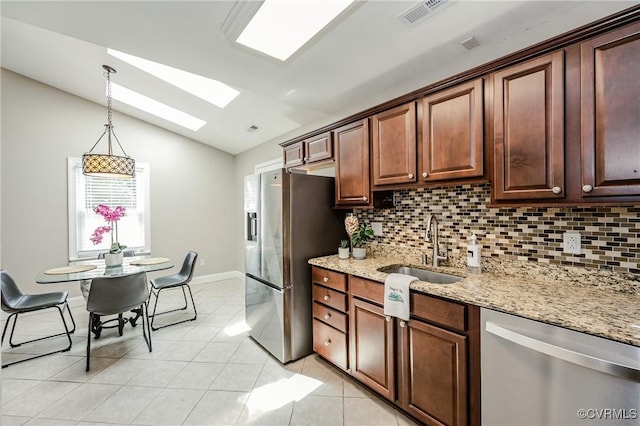 9286 Hungary Rd, Glen Allen, VA 23060 - kitchen featuring appliances with stainless steel finishes, a skylight, vaulted ceiling, backsplash, and light tile patterned floors
