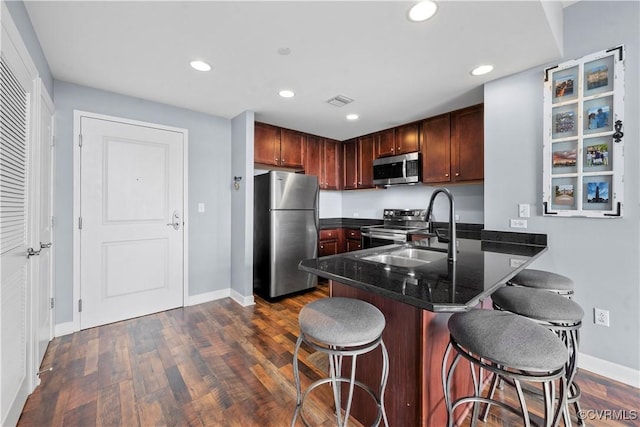 1101 Haxall Pt Unit U712, Richmond, VA 23219 - kitchen featuring stainless steel appliances, a kitchen bar, a peninsula, recessed lighting, and dark wood-style flooring