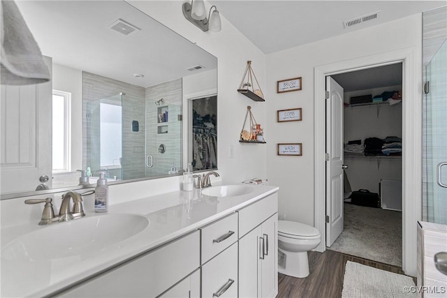 7012 Hapsburg Ct, Henrico, VA 23231 - bathroom with a spacious closet, a stall shower, double vanity, and wood finished floors