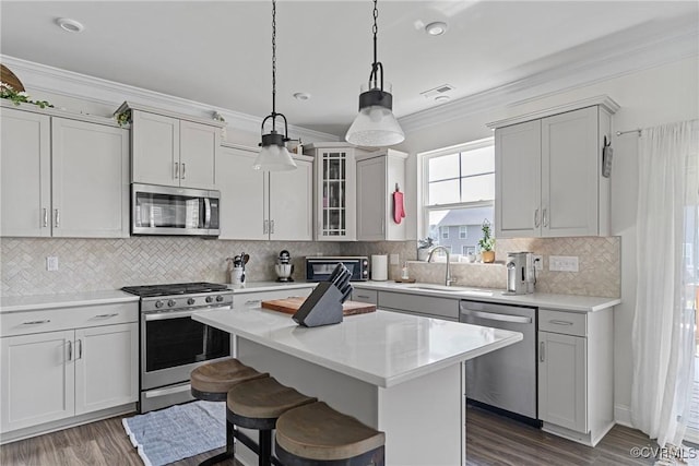 7012 Hapsburg Ct, Henrico, VA 23231 - kitchen with stainless steel appliances, ornamental molding, light countertops, dark wood finished floors, and a kitchen breakfast bar