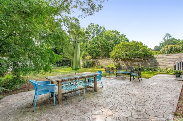 4006 Chevy Chase St, Richmond, VA 23227 - fenced backyard featuring outdoor dining space, a patio, and view of wooded area