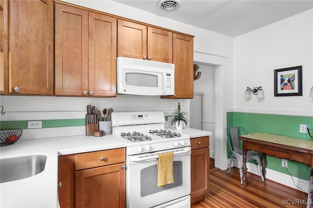 4006 Chevy Chase St, Richmond, VA 23227 - kitchen featuring white appliances, brown cabinets, light wood finished floors, and light countertops