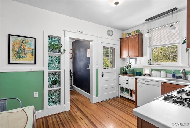 4006 Chevy Chase St, Richmond, VA 23227 - kitchen with white dishwasher, light wood-style flooring, light countertops, brown cabinetry, and plenty of natural light