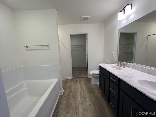 4913 Bailey Woods Ln, Midlothian, VA 23112 - bathroom featuring a spacious closet, wood finished floors, a garden tub, and double vanity