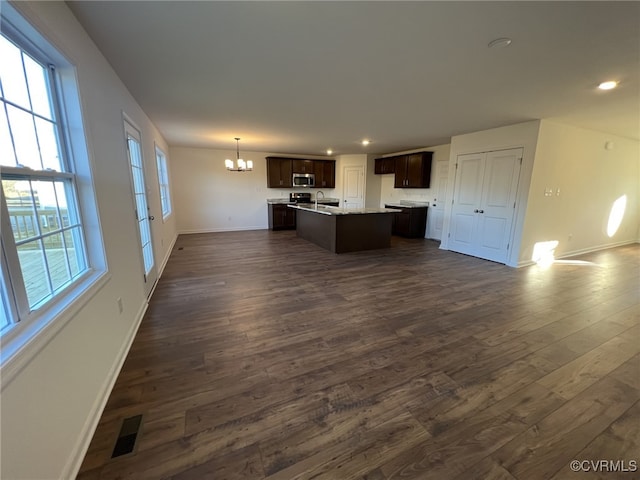 4913 Bailey Woods Ln, Midlothian, VA 23112 - kitchen with stainless steel microwave, a chandelier, dark brown cabinetry, open floor plan, and dark wood-type flooring
