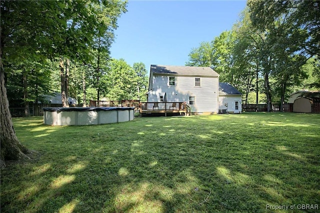 8187 Lord Fairfax Cir, Gloucester, VA 23061 - rear view of house featuring a storage shed, a wooden deck, a fenced backyard, and a covered pool