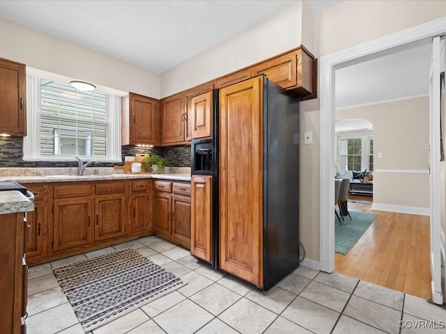 3303 Woodrow Ave, Richmond, VA 23222 - kitchen with paneled fridge with ice dispenser, light countertops, brown cabinets, tasteful backsplash, and ornamental molding