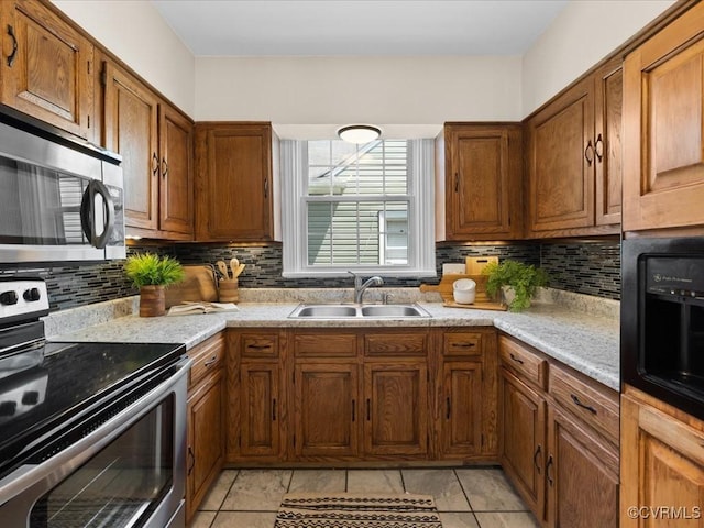 3303 Woodrow Ave, Richmond, VA 23222 - kitchen with appliances with stainless steel finishes, brown cabinetry, decorative backsplash, and light countertops