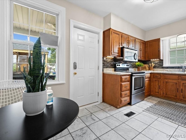 3303 Woodrow Ave, Richmond, VA 23222 - kitchen featuring stainless steel appliances, healthy amount of natural light, brown cabinets, and light countertops