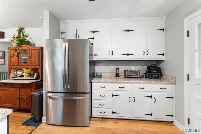 1200 Hybla Rd, Richmond, VA 23236 - kitchen with freestanding refrigerator, decorative backsplash, light wood-style floors, white cabinetry, and light stone countertops