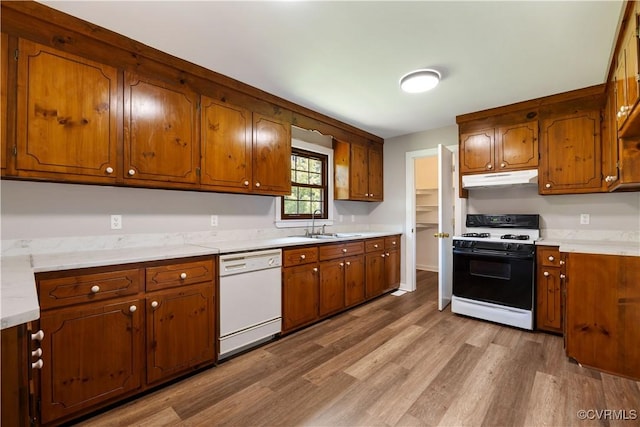 10324 Lamore Dr, Disputanta, VA 23842 - kitchen with white appliances, under cabinet range hood, wood finished floors, and brown cabinets