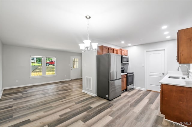 6512 N Stevens Hollow Dr, Chesterfield, VA 23832 - kitchen with appliances with stainless steel finishes, a chandelier, recessed lighting, light wood finished floors, and brown cabinetry