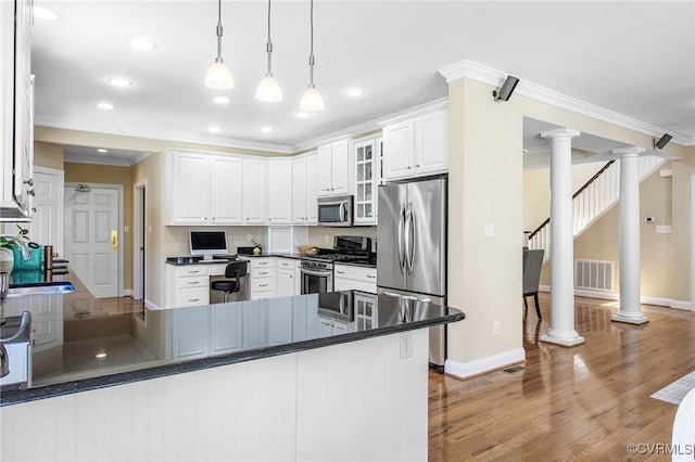 1204 Bowden Rd, Henrico, VA 23229 - kitchen with stainless steel appliances, a peninsula, decorative columns, wood finished floors, and crown molding