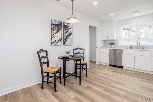 25713 Simmons Ave, North Dinwiddie, VA 23803 - kitchen with stainless steel dishwasher, light wood-style flooring, light countertops, white cabinetry, and recessed lighting