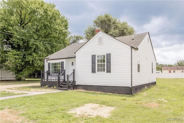 25713 Simmons Ave, North Dinwiddie, VA 23803 - view of front facade with a shingled roof, a chimney, and a front lawn