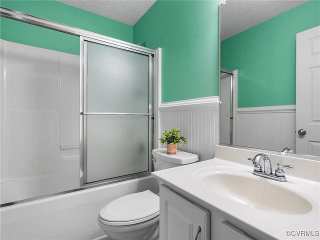 621 Fort Lowry Ln, Dunnsville, VA 22454 - bathroom featuring a wainscoted wall, vanity, enclosed tub / shower combo, and a textured ceiling