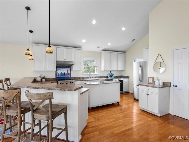 621 Fort Lowry Ln, Dunnsville, VA 22454 - kitchen with freestanding refrigerator, white cabinets, light wood-type flooring, a kitchen bar, and a peninsula