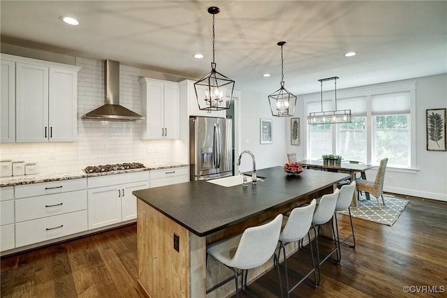 2500 Madison Station Ct, Henrico, VA 23233 - kitchen featuring wall chimney exhaust hood, stainless steel appliances, backsplash, dark wood-style floors, and a breakfast bar