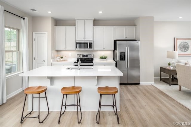 2211 Palm Ct, Sandston, VA 23150 - kitchen with stainless steel appliances, light wood-style floors, light countertops, a kitchen island with sink, and recessed lighting