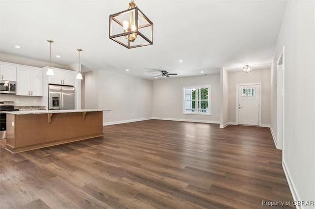 5883 Mill Race Pl, Gloucester, VA 23061 - kitchen with appliances with stainless steel finishes, recessed lighting, a kitchen bar, dark wood-type flooring, and white cabinetry