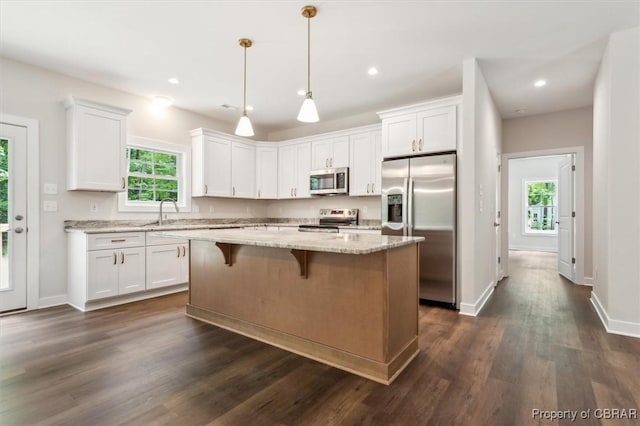 5883 Mill Race Pl, Gloucester, VA 23061 - kitchen with stainless steel appliances, white cabinets, a kitchen island, light stone countertops, and dark wood-type flooring