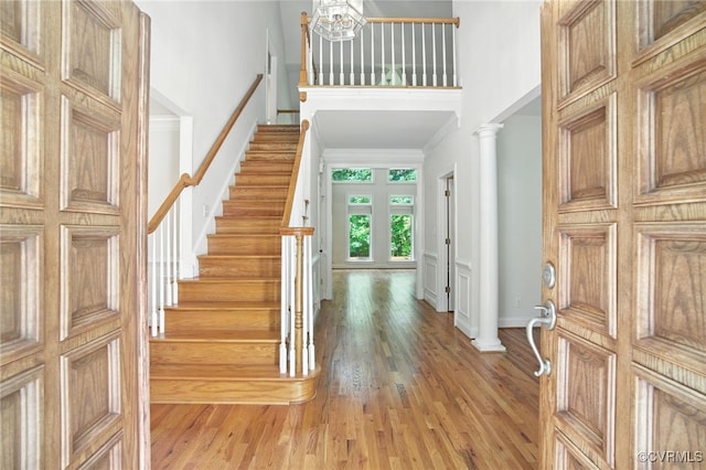 3007 Tranbycroft Way, Sandy Hook, VA 23153 - foyer entrance with light wood-style flooring, stairway, a towering ceiling, ornamental molding, and decorative columns