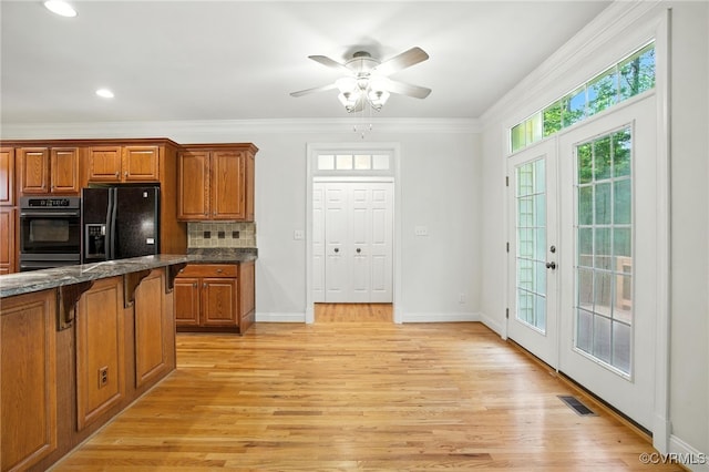 3007 Tranbycroft Way, Sandy Hook, VA 23153 - kitchen with black appliances, a kitchen bar, brown cabinetry, french doors, and ornamental molding