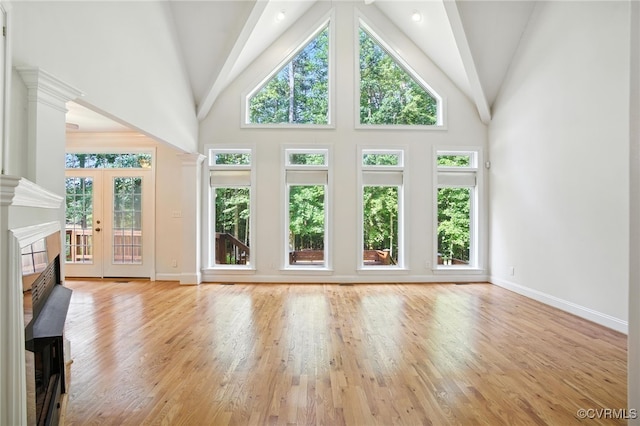 3007 Tranbycroft Way, Sandy Hook, VA 23153 - unfurnished living room with wood finished floors, healthy amount of natural light, high vaulted ceiling, a fireplace with flush hearth, and decorative columns