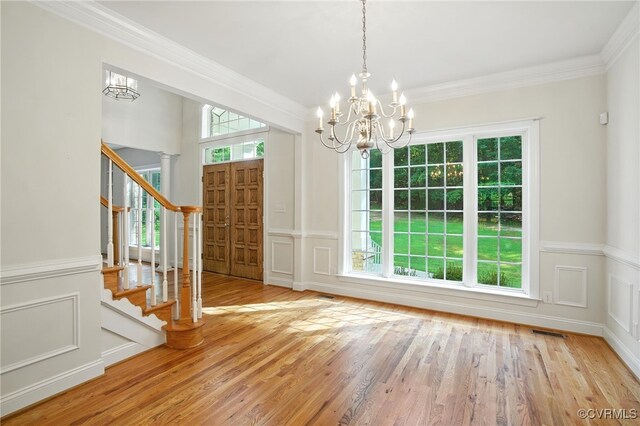 3007 Tranbycroft Way, Sandy Hook, VA 23153 - unfurnished dining area featuring a chandelier, stairs, crown molding, wood finished floors, and a decorative wall