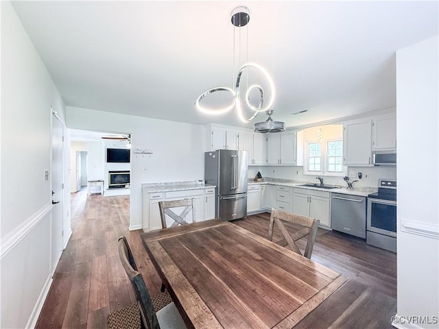 7908 Capistrano Dr, Henrico, VA 23227 - dining area featuring dark wood-style flooring, ceiling fan, and a glass covered fireplace