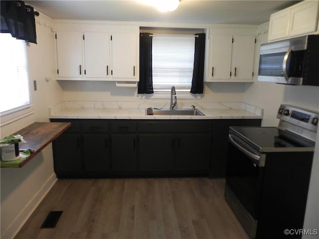 6325 Maple Rd, Quinton, VA 23141 - kitchen with appliances with stainless steel finishes, white cabinetry, wood finished floors, and dark cabinets