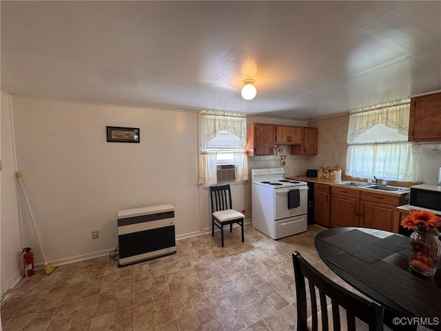 875 Islington Rd, Warsaw, VA 22572 - kitchen with white electric stove, heating unit, plenty of natural light, and brown cabinetry