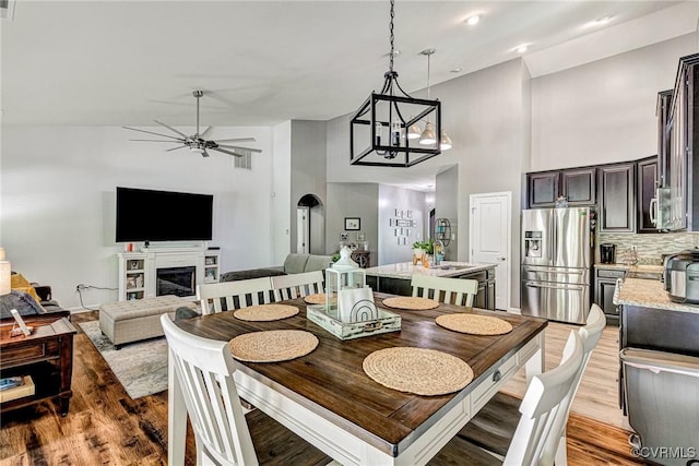 5858 Pilmour Dr, Providence Forge, VA 23140 - dining room with high vaulted ceiling, wood finished floors, a ceiling fan, a glass covered fireplace, and a chandelier