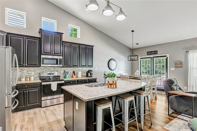 5858 Pilmour Dr, Providence Forge, VA 23140 - kitchen with appliances with stainless steel finishes, high vaulted ceiling, a kitchen bar, a center island with sink, and hanging light fixtures