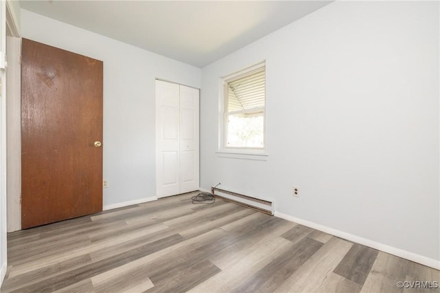 3317 Gaulding Ln, Richmond, VA 23223 - unfurnished bedroom featuring baseboard heating, wood finished floors, and a closet